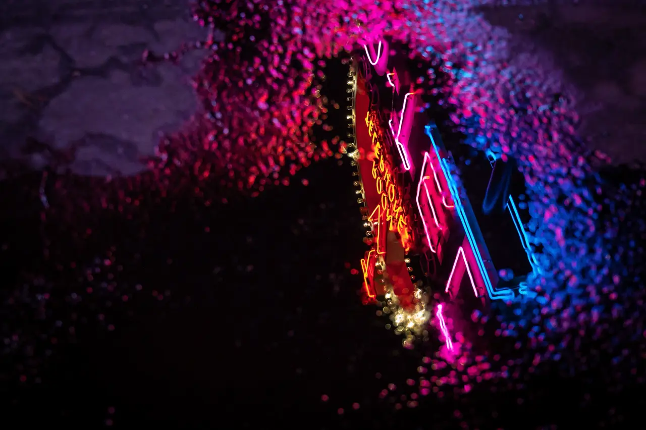 Neon reflected in a rain puddle on a PVM broadcast monitor — Original